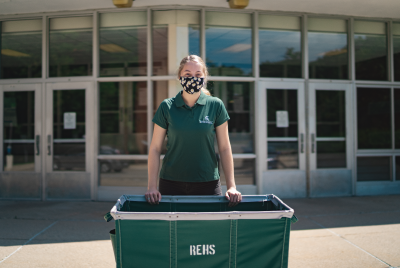Student in mask with green cart
