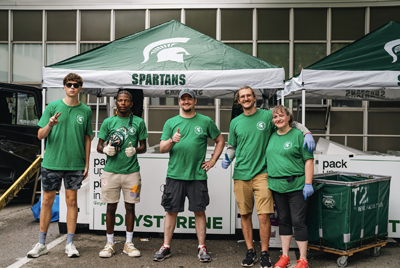 Image of five spartans posing in front of a recycling bin during move-in